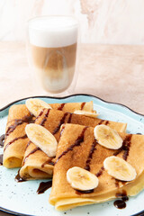 Pancakes with banana and chocolate on a plate.