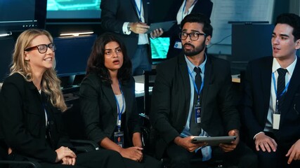 Diverse team of business professionals and IT experts actively viewing a presentation, discussing strategy, and collaborating in a modern, dark tech office. Corporate leadership and innovation - Powered by Adobe