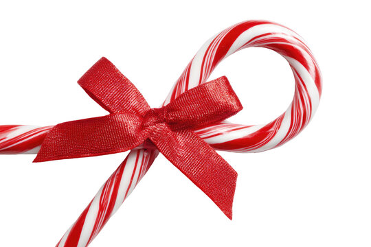 Sweet candy canes crossed, tied with a bright red bow on black - Powered by Adobe