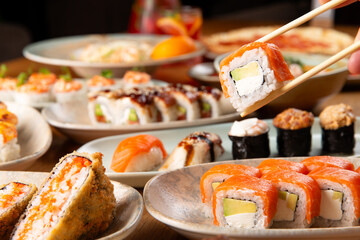 Holding a salmon roll with chopsticks.