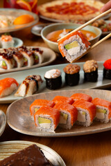 Holding a salmon roll with chopsticks.