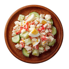 Crab salad with egg and cucumber slices on a wooden plate, top view