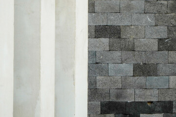 Close-up view of a wall with a contrast of white and gray brick textures.