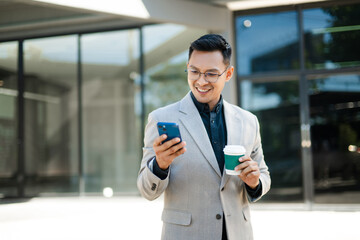 Fototapeta premium Confident businessman enjoying phone conversation and coffee outdoors, representing success, modern communication, and professional lifestyle.