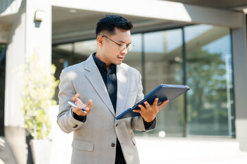 Fototapeta premium Focused businessman planning new goals and writing business ideas in notebook outdoors, symbolizing motivation, success, and fresh start in professional life.