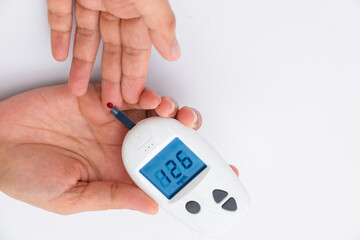 Woman's hands checking diabetes and hyperglycemia with digital blood sugar meter. Healthcare and...