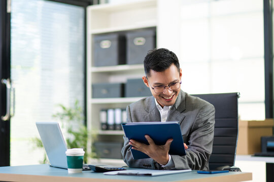 Business man using tablet and laptop for doing math finance on an office desk, tax, report, accounting, statistics, - Powered by Adobe