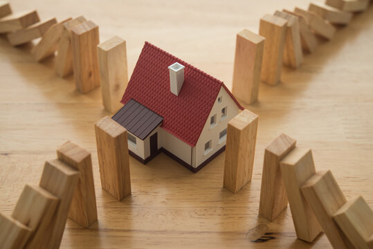 Domino are falling around effect to modern house. Mortgage loan for buying home or real estate property, money risk management, home finance problem, foreclosure and bankruptcy and so on concept.