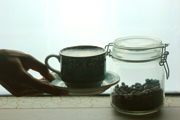 holding a cup of hot coffee