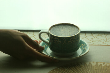 holding a cup of hot coffee