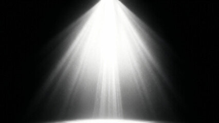 Bright white spotlight beam shining down from above against a dark black background creating a dramatic illuminated effect