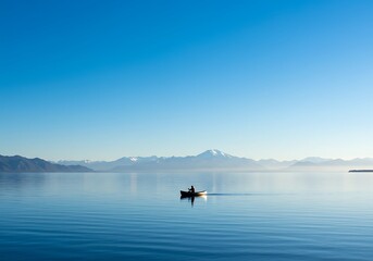 Boat on calm water with mountains and clear blue sky