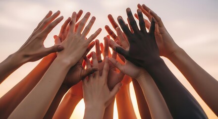Diverse hands reaching up together, symbolizing unity, teamwork, and collaboration against a warm, sunset background.