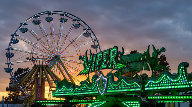 View at big Ferris Wheel against dramatic evening sky. Amusement rides in Hillsboro Fairground, Oregon