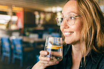 Happy Woman Drinking Water in Cafe, Healthy Lifestyle and Refreshment, Natural Light Close-Up
