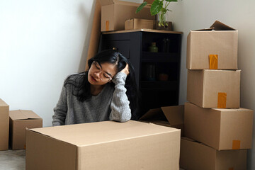 Fototapeta premium Young woman feels dizzy next to cardboard box when she wants to move to new house