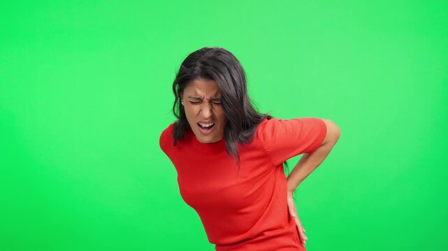 Woman experiencing sudden lower back pain on green screen