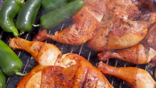 Spicy grilled chicken and jalape&ntilde;o peppers cooking on a hot barbecue grill