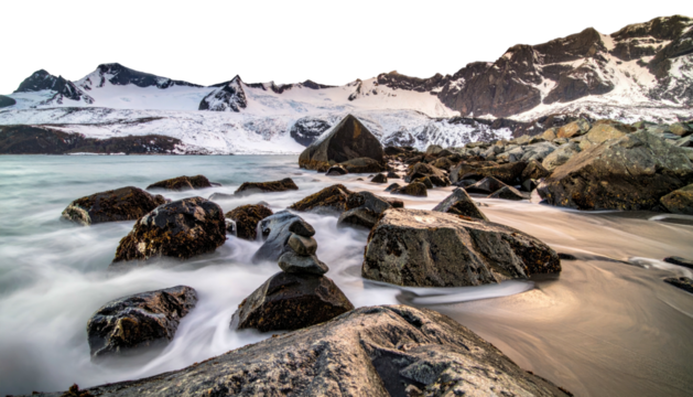 Snowy mountain backdrop with rocky beach and blurred ocean waves