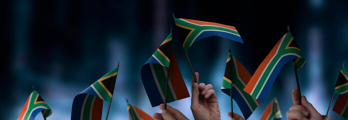 South Africa flags in their hands on a blurred urban background