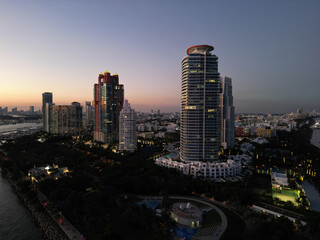 Miami Beach sunset aerial view. Downtown Miami skyline at dusk. South Beach neon lights at night. Tropical Miami waterfront panorama. Ocean Drive Art Deco buildings. Aerial view of Miami coastline.