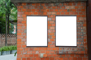 Double blank white posters on red brick wall. Urban background with copy space for advertisement.