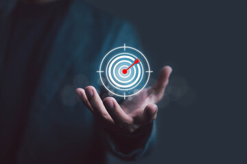 Business success concept with digital target and arrow hitting bullseye above businessman hand, marketing strategy, focus on goal, precision planning, leadership, and achievement motivation background
