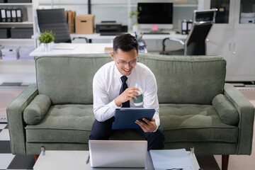 Mature businessman calculate and analyzing graph document financial with report and laptop in...