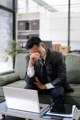 stressed Asian businessman working in the office. Businessman thinking too much work concept in the office.