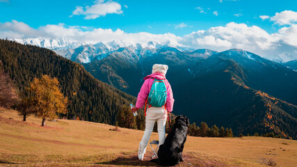 Asian woman as her dog rest and enjoy of the view as sitting on a chair. Hiking in nature.  in Mestia Mountain ,Georgia