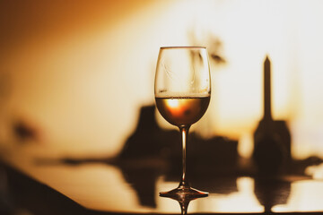 Shallow depth of field (selective focus) details with a glass of white wine on a table in a dark...