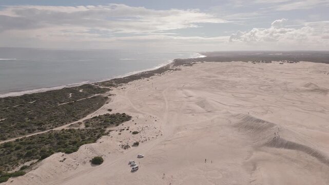 Aerial footage of the Lancelin Sand Dunes alongside the vast Indian Ocean in Perth, Western Australia.