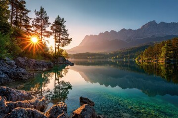Stunning summer sunrise over Eibsee lake reflecting Zugspitze mountain with trees framing the serene landscape