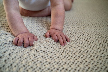 Close Up of Child Hands on Neutral Baby Blanket