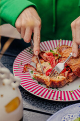 Girl cutting a croissant with a knife and fork