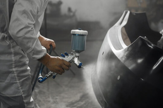 Application of primer before the main spray painting of the car bumper. - Powered by Adobe