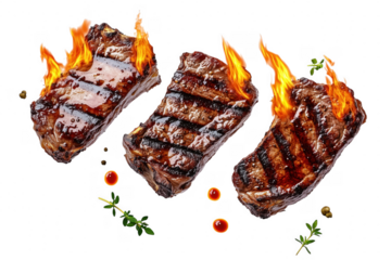 Fiery grilled steaks with herbs isolated on a transparent background