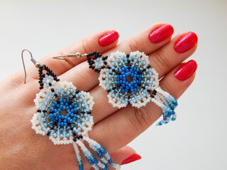 A beaded earrings lies in a hand