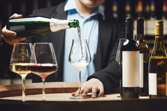 Sommelier Pouring Champagne into Glass in Cellar