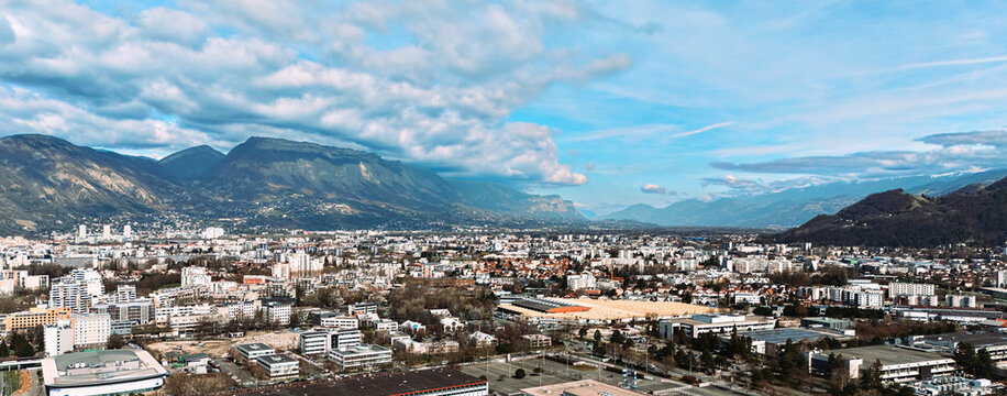 Panoramic cityscape with mountains under dramatic cloud formations