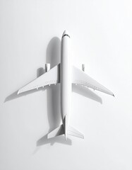 Overhead view of a white model airplane casting a shadow