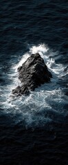 Dark ocean waves crash over lone rock