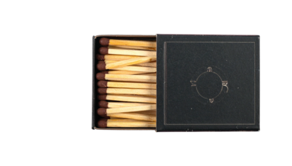 Open matchbox exposing rows of wooden sticks with dark ends
