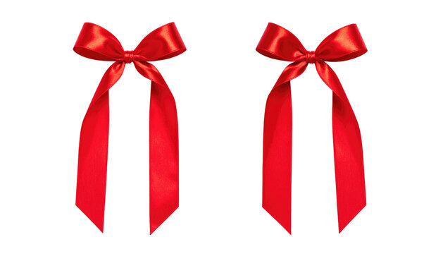 Two vibrant red satin bows with dangling ribbons isolated on a dark backdrop create a festive holiday theme