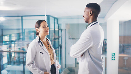 Obraz premium Medical, student doctors and talking for healthcare collaboration, knowledge sharing and advice. Case discussion, teamwork and man with woman for planning clinical diagnosis, internship and helping.