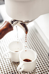 Brewed Espresso Dripping From a Professional Coffee Machine Into White Cups During a Morning Coffee Ritual