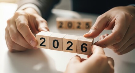 Close-up of hands adjusting blocks from 2025 to 2026 — highlighting change, growth, and ambition