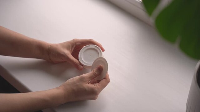 Returning used nicotine pouch back into tin on desk. High quality 4k footage