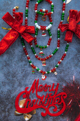 Christmas themed handmade necklace and bracelets on a stone background surrounded by Christmas bands and decorations.