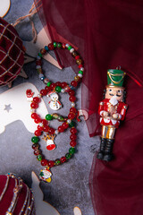 Christmas themed handmade pendant bracelets on festive background surrounded by Christmas balls and nutcracker.